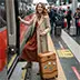 A female tourist with a suitcase stepping onto a train at the station, heading to a private transfer connection